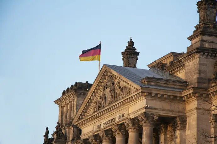 The german flag flies above a historic building.